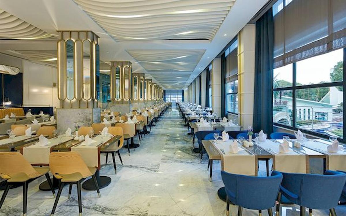 Restaurantbereich im Limak Atlantis Deluxe Hotel & Resort mit gedeckten Tischen und modernen Möbeln.
