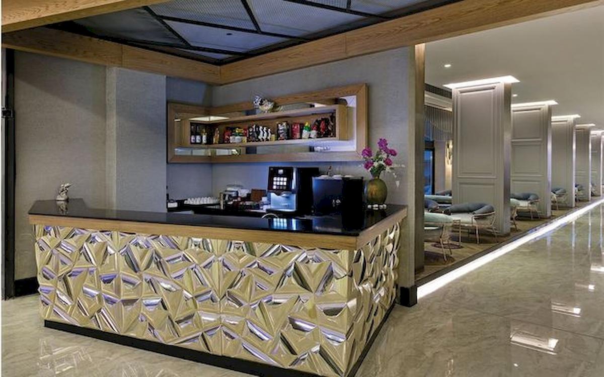 Innenansicht der Rezeption des Limak Atlantis Deluxe Hotel & Resort mit modernem Design, Marmorboden und geometrischen Mustern.