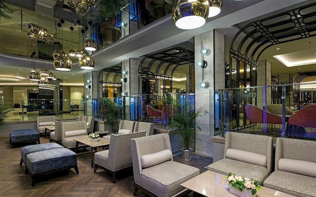 Innenansicht der Lobby des Limak Atlantis Deluxe Hotel & Resort mit Möbeln und Pflanzen.