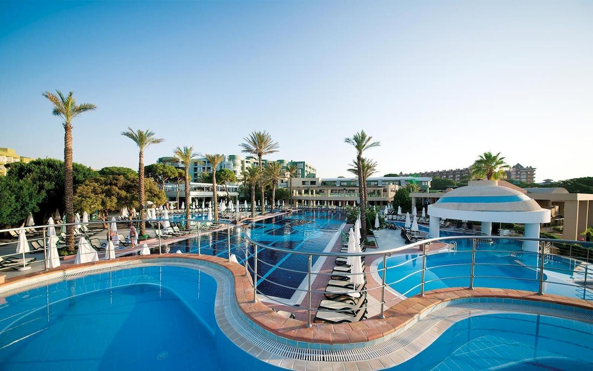 Außenpool des Limak Atlantis Deluxe Hotel & Resort mit Sonnenliegen und Palmen