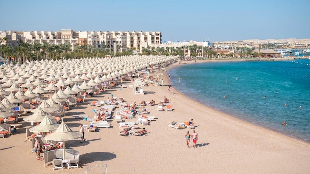 Luftaufnahme vom Strand des Grand Hotel Hurghada mit vielen Liegen und Sonnenschirmen.