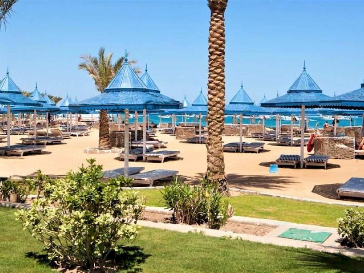 Strand mit blauen Sonnenhuten und Palmen am Grand Hotel Hurghada