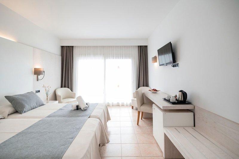Doppelzimmer im Hotel Princesa Playa mit zwei Betten, Fernseher und Schreibtisch