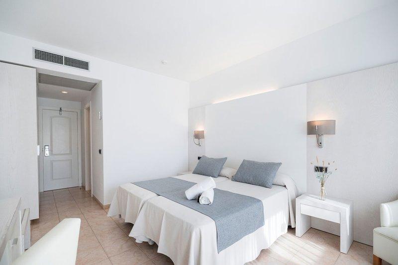 Hotelzimmer im Princesa Playa mit zwei Betten, weißen Wänden und einem weißen Nachttisch.