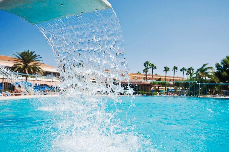 Wasserfall im Schwimmbad des Princesa Playa Hotels, das in den Pool fällt.