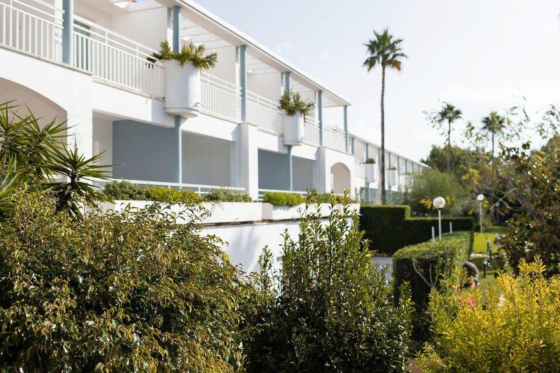 Außenansicht des weißen Hotel Princesa Playa mit Balkonen und Pflanzen.