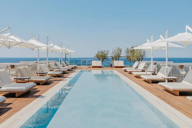 Pool-Terrasse des Villa Le Blanc Gran Melia Hotels mit weißen Liegestühlen und Sonnenschirmen