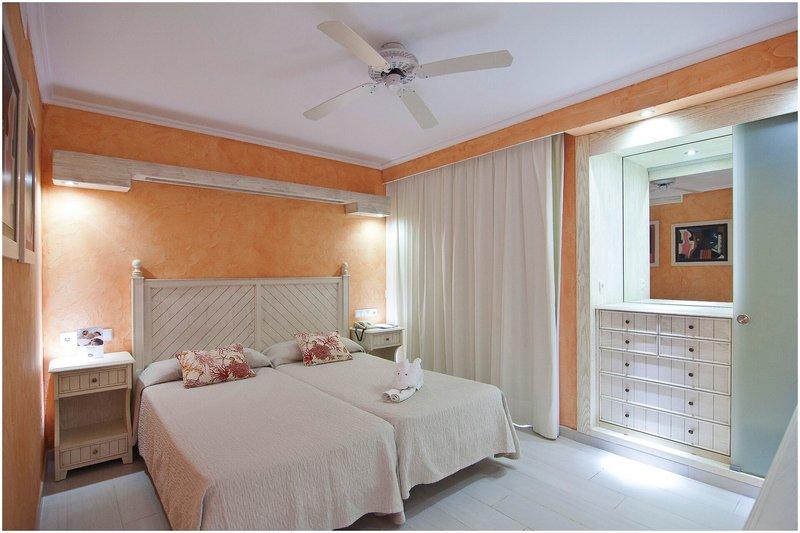 Doppelzimmer im Royal Son Bou Family Club mit zwei Betten, Nachttischen und einem Kleiderschrank.