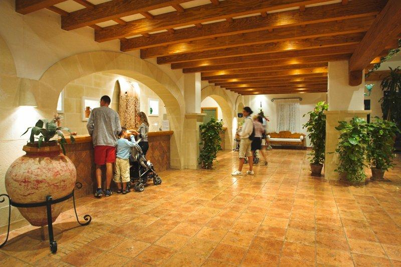 Empfangsbereich des Royal Son Bou Family Clubs mit Holzbalkendecke und vielen Pflanzen.