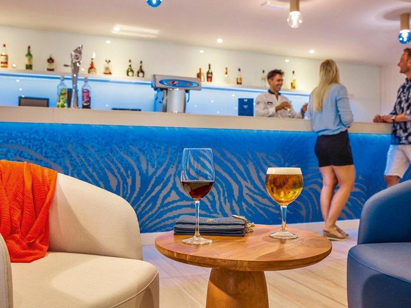 Bar im Victoria Menorca Hotel mit Getränken und Kunden hinter der Theke