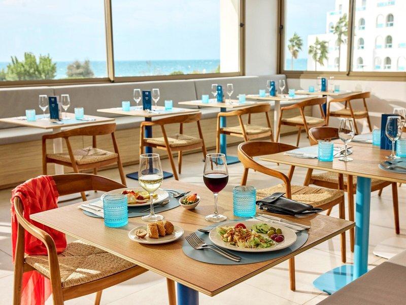 Frühstückstisch auf der Terrasse des Victoria Menorca Hotels mit Blick auf das Meer.
