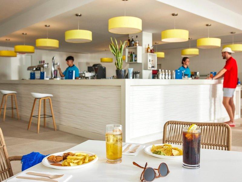 Restaurantbar im Victoria Menorca Hotel mit Gästen, die Speisen und Getränke genießen.
