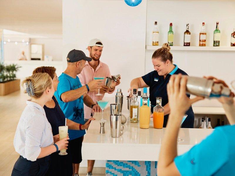 Gäste lernen am Cocktailstand im Hotel Victoria Menorca Cocktails zuzubereiten