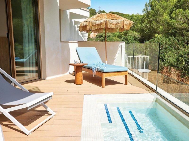 Terrasse des Victoria Menorca Hotels mit zwei Liegen, einem Tisch und einem kleinen Pool