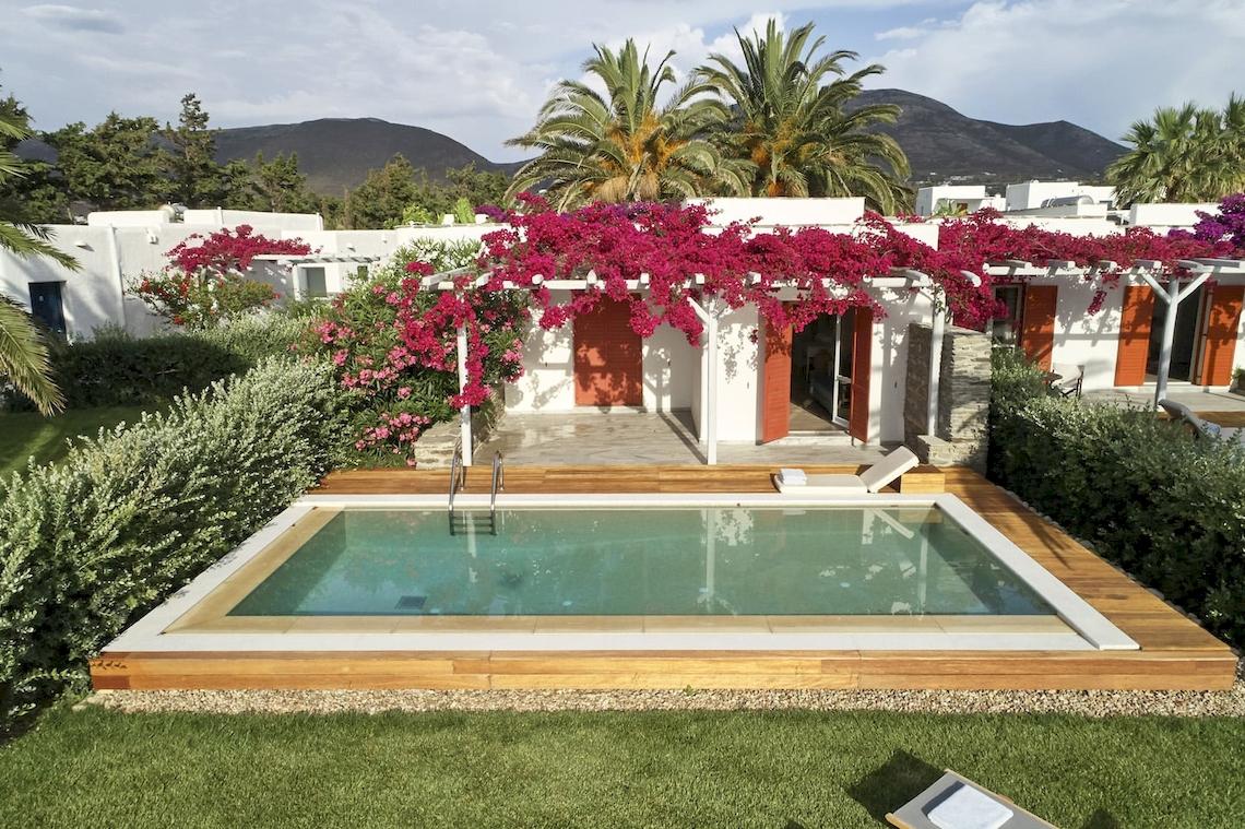 Außenpool des Yria Island Boutique Hotel & Spa mit weißen Gebäuden und bunten Blumen.