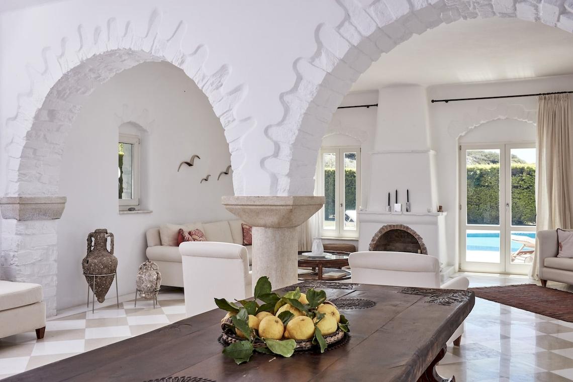 Wohnbereich des Yria Island Boutique Hotel mit einem großen Tisch, einer Schüssel voller Zitronen und einem bogenförmigen Eingang.
