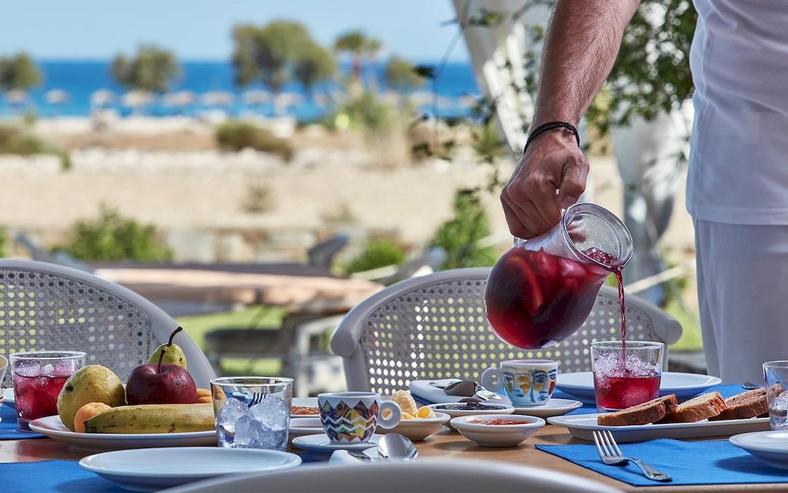 Frühstückstisch im Freien im Yria Island Boutique Hotel & Spa mit Früchten und Getränken.