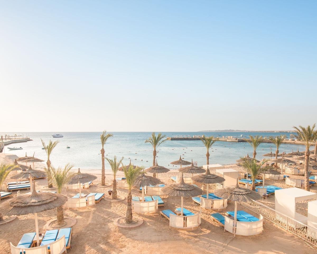 Strand des Pickalbatros Aqua Park Resorts in Hurghada mit Sonnenschirmen und Liegen