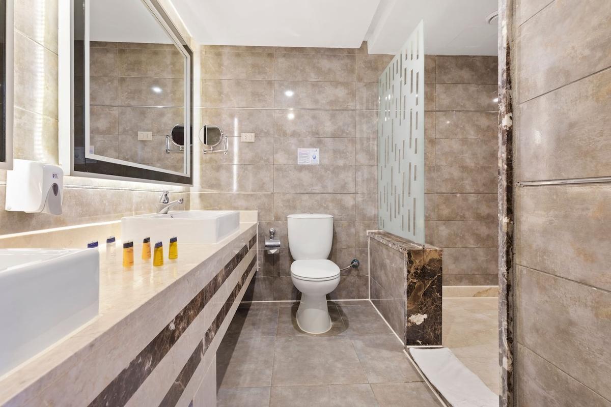 Badezimmer im Pickalbatros Aqua Park Resort in Hurghada mit Waschbecken, Toilette und Dusche.