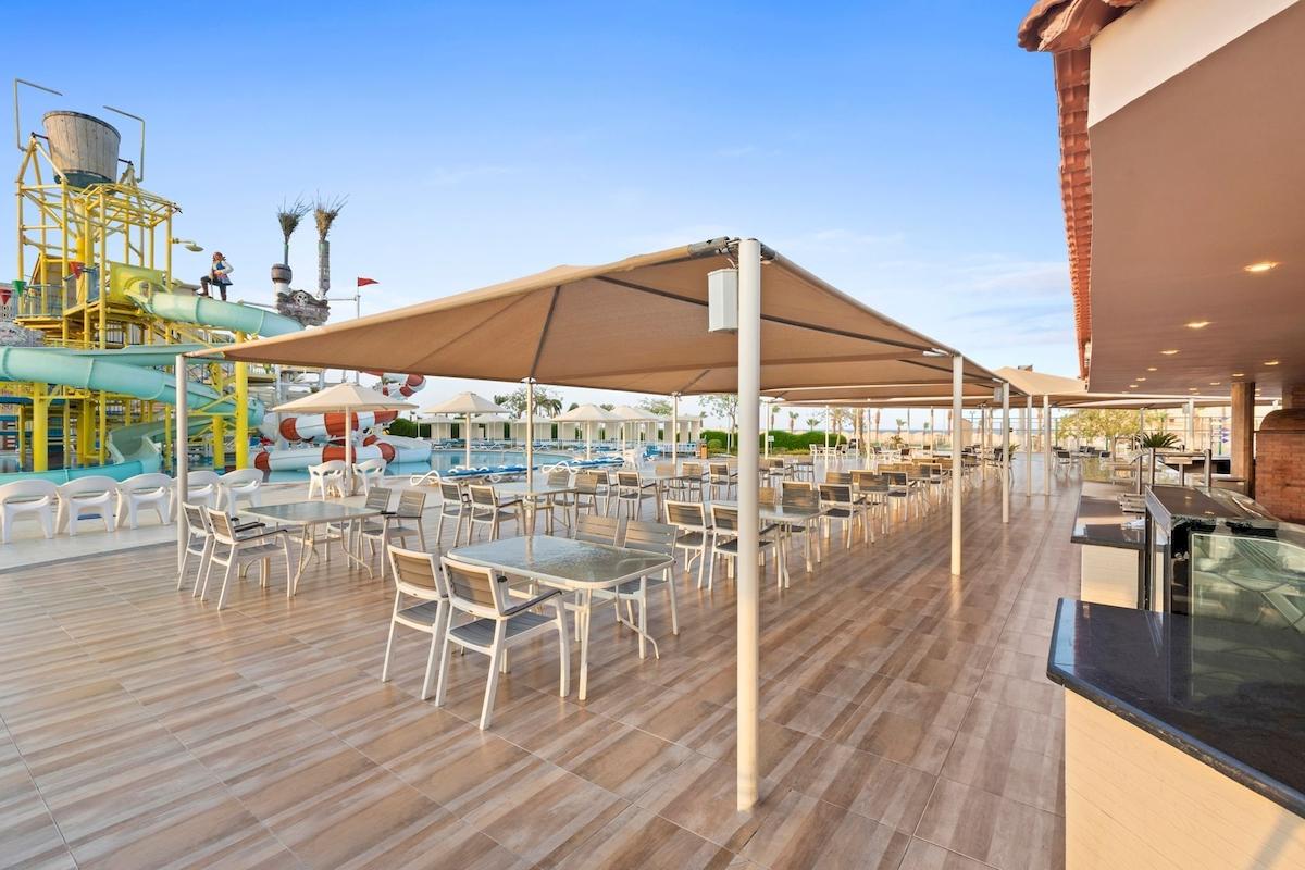 Terrasse des Pickalbatros Aqua Park Resorts mit Tischen, Stühlen und Sonnenschirmen