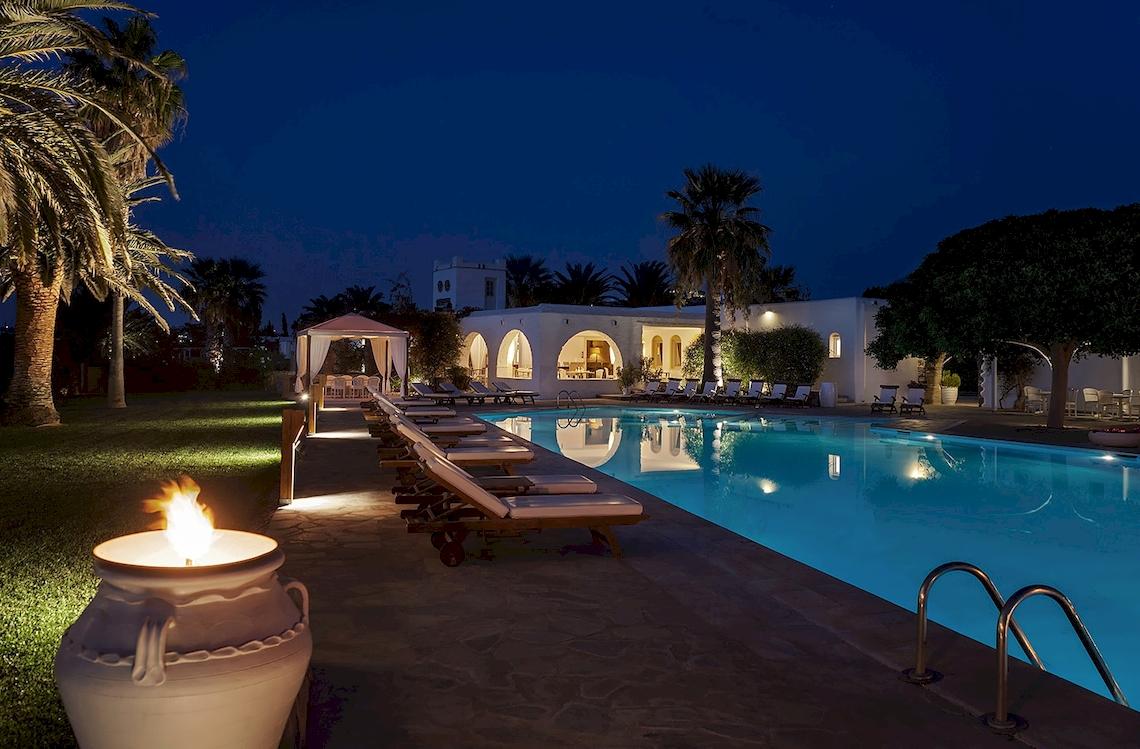 Nachtansicht des Yria Island Boutique Hotel & Spa mit Swimmingpool und Liegestühlen.