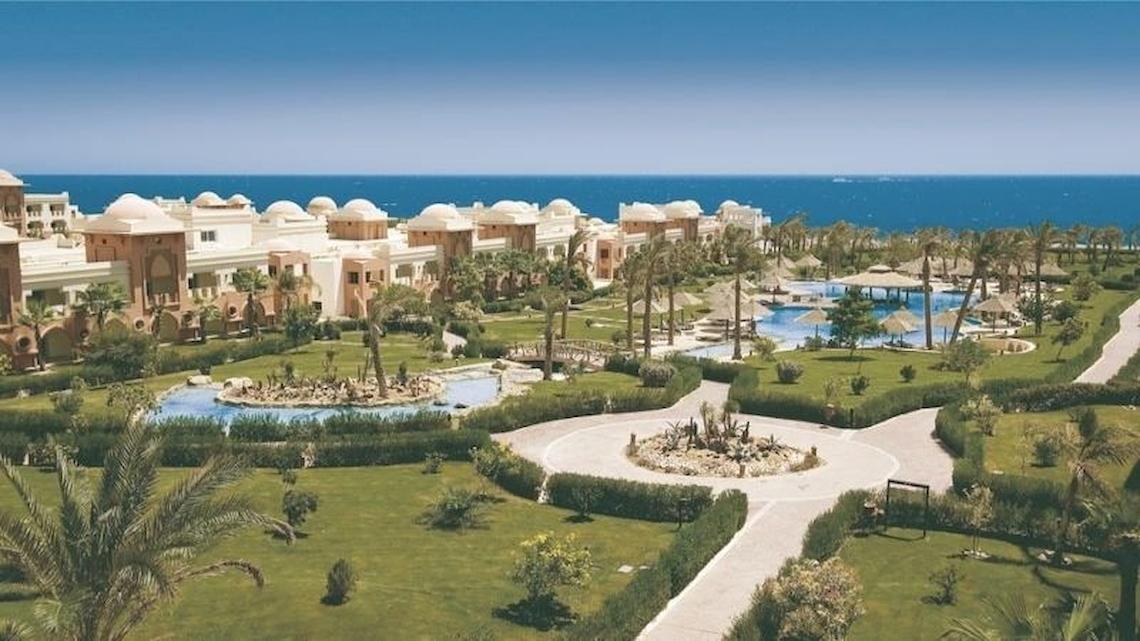 Außenansicht des Serenity Alpha Beach Resorts mit Hotelgebäuden, Swimmingpools und Meer im Hintergrund.