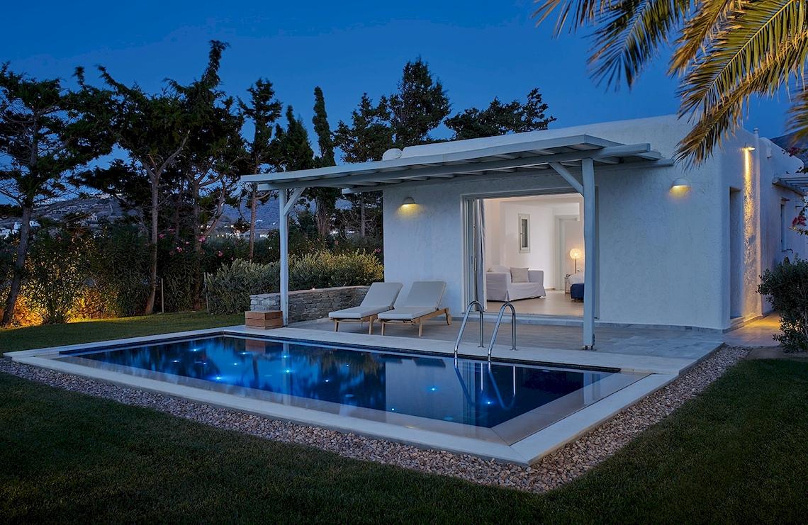 Außenbereich des Yria Island Boutique Hotel & Spa bei Nacht mit Pool und Loungemöbeln.