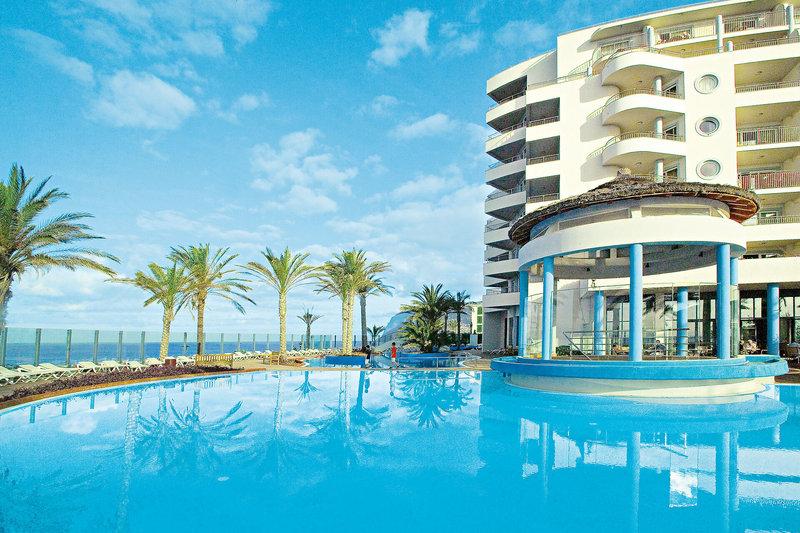 Außenbereich des Pestana Grand Premium Ocean Resort mit großem Pool und tropischen Palmen.