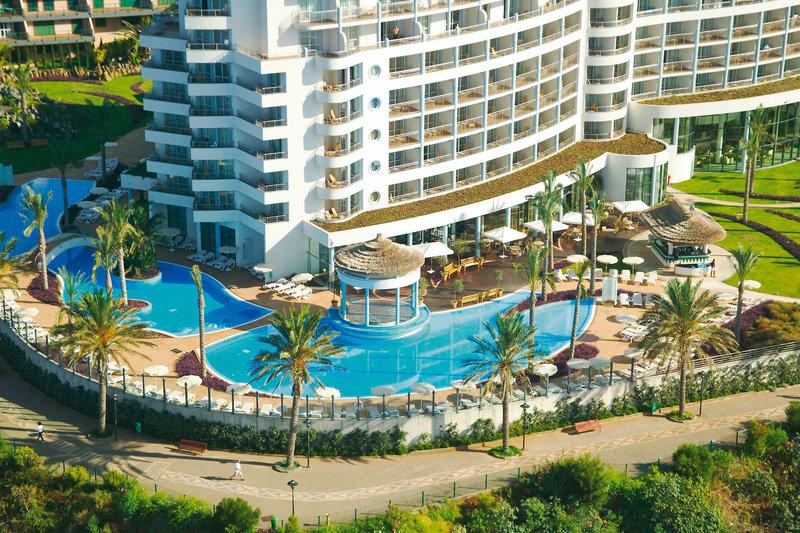 Luftaufnahme des Pestana Grand Premium Ocean Resorts mit Swimmingpool und Sonnenliegen.