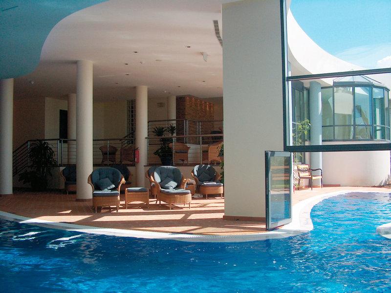Poolbereich des Pestana Grand Premium Ocean Resorts mit Loungemöbeln und Sonnenlicht.