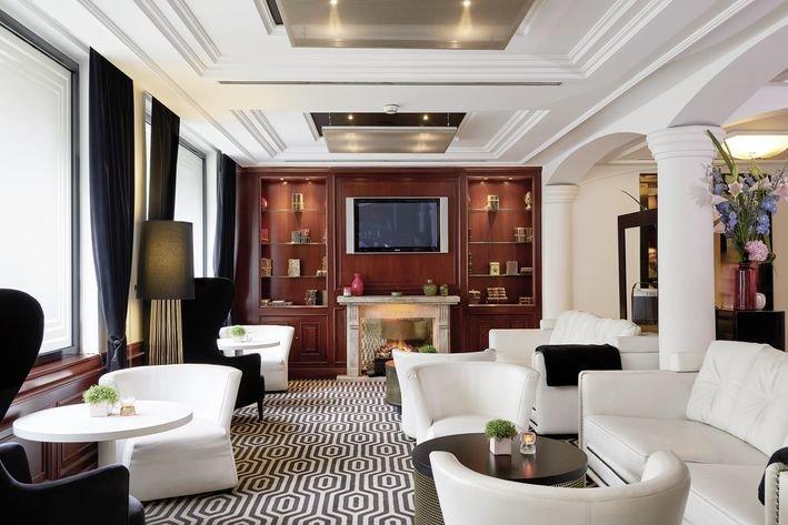 Lobby der Villa Marquis Melia Collection mit weißen Möbeln und Holzelementen.