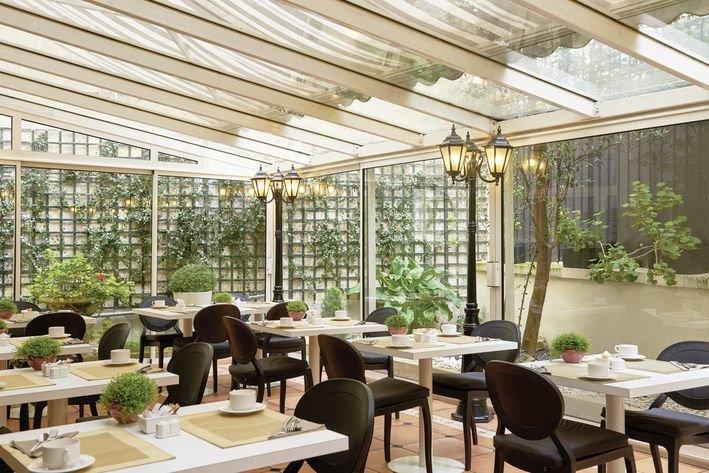 Restaurant der Villa Marquis Melia Collection mit Tischen, Stühlen und Pflanzen.