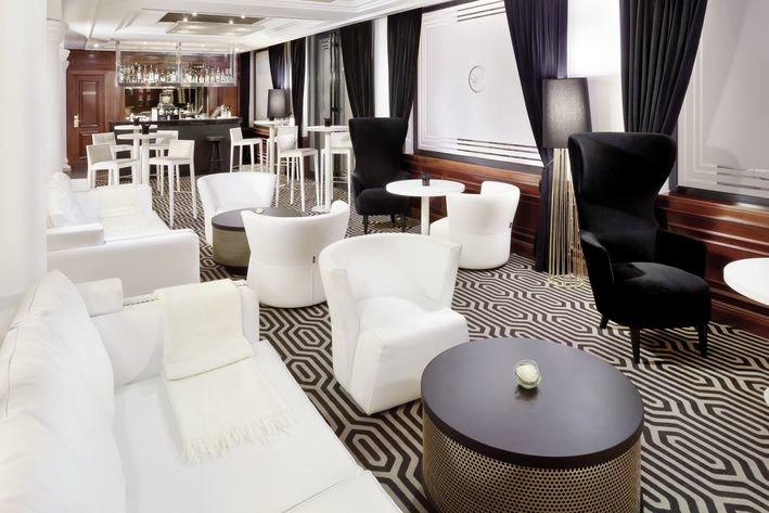Villa Marquis Melia Collection Hotellounge mit weißen Möbeln und schwarzen Akzenten.