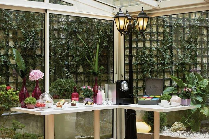 Gartenlounge der Villa Marquis Melia Collection mit Tischen, Pflanzen und Getränkeautomaten.