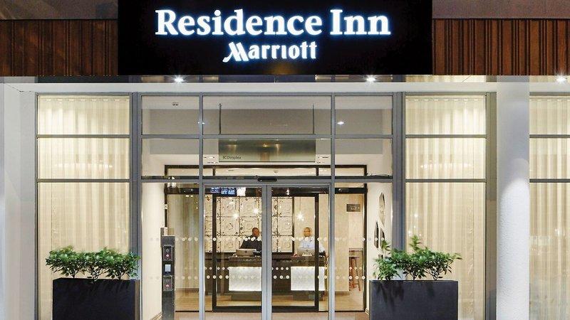 Eingang des Residence Inn by Marriott London Bridge mit Schild und zwei Mitarbeitern im Innenbereich.