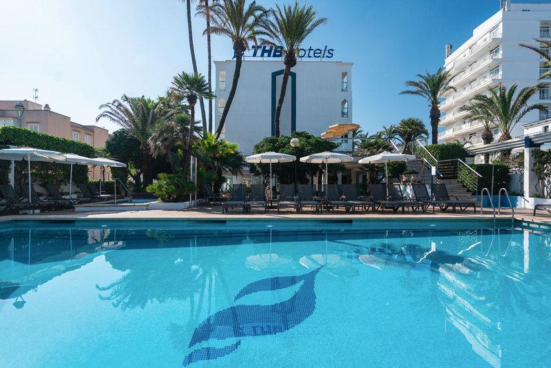 Ein großer Pool des THB Gran Playa Hotels mit Sonnenliegen, Sonnenschirmen und Gebäude im Hintergrund.