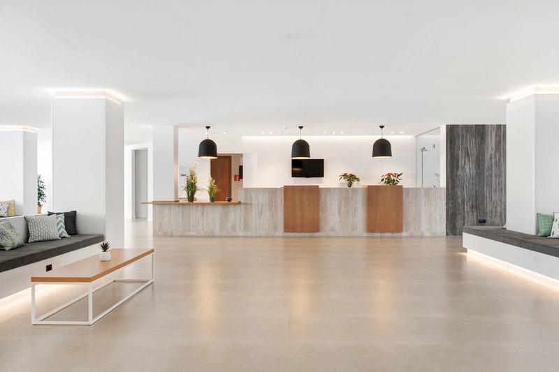 Innenansicht der Lobby des THB Gran Playa Hotel mit hellen Wänden, Betonboden und Beleuchtung.
