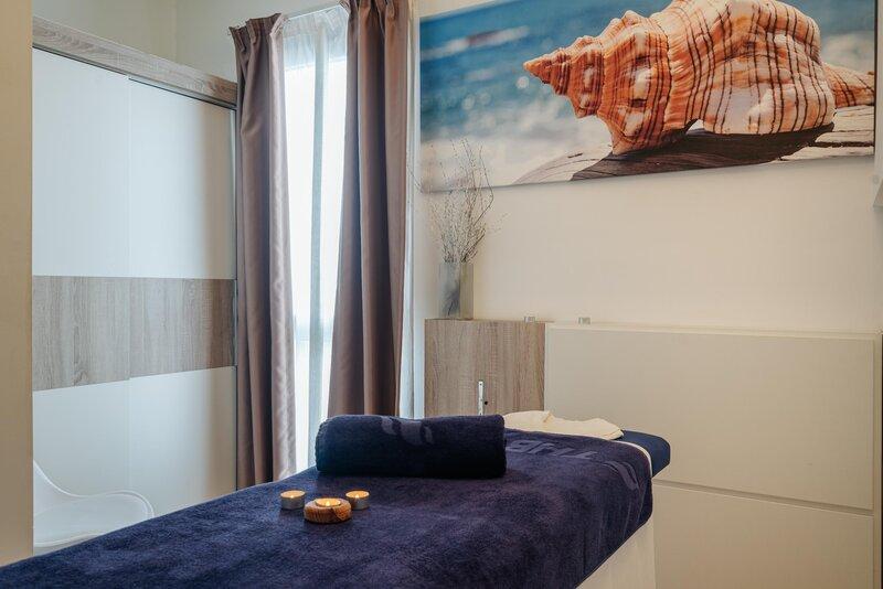 Massagebereich im THB Gran Playa Hotel mit Liege, Kerzen und Strandmotiv