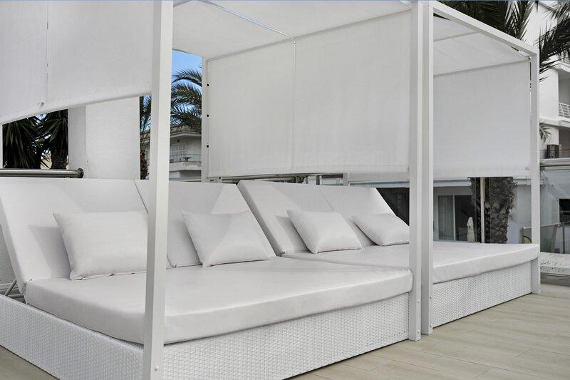 Loungebereich des THB Gran Playa Hotels mit weißen Sonnenliegen und Vorhängen.