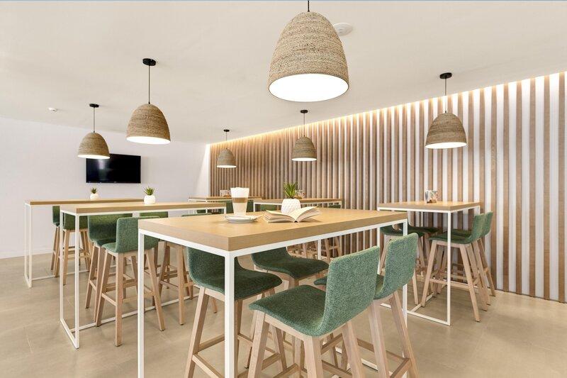 Innenraumdesign des THB Gran Playa Hotel mit Tischen, Stühlen und Wanddekoration.