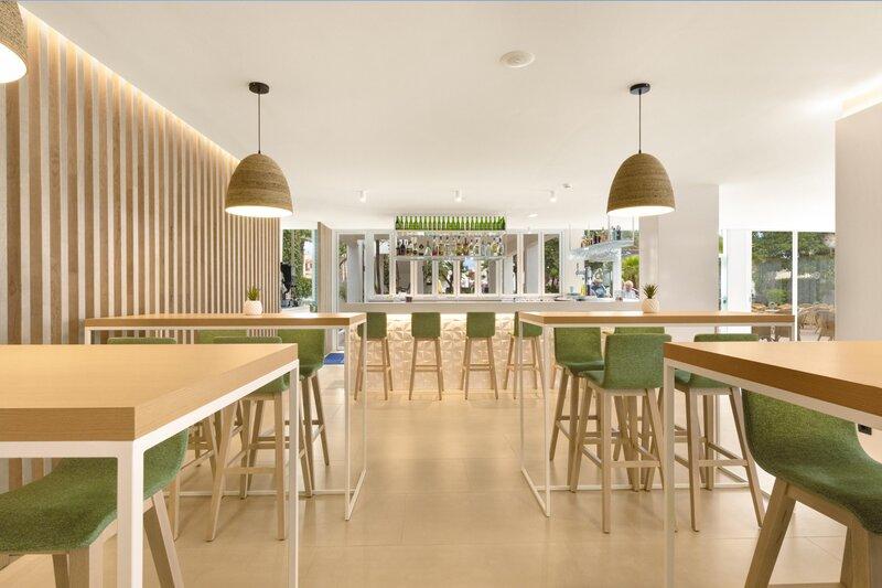 Innenbereich der Bar im THB Gran Playa Hotel mit grünen Stühlen und Holztischen.