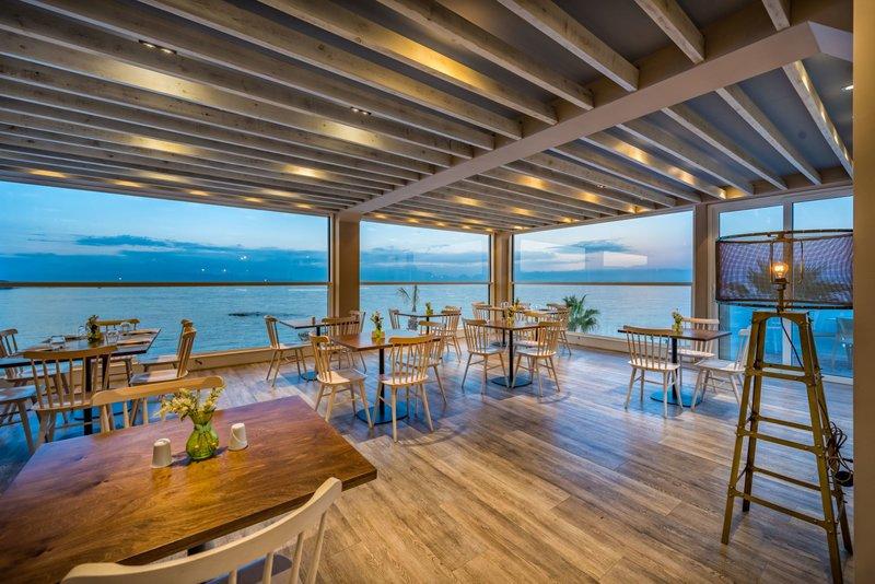 Innenansicht des Restaurants im Alexandra Beach Resort mit Blick auf das Meer.