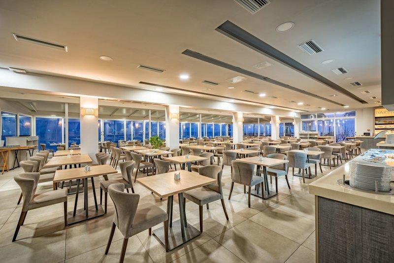 Innenraum des Restaurants im Alexandra Beach Resort mit vielen Tischen und Stühlen.