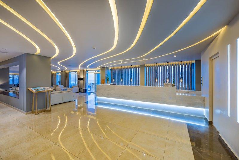Lobby des Alexandra Beach Resorts mit moderner Beleuchtung und Marmorrezeption.