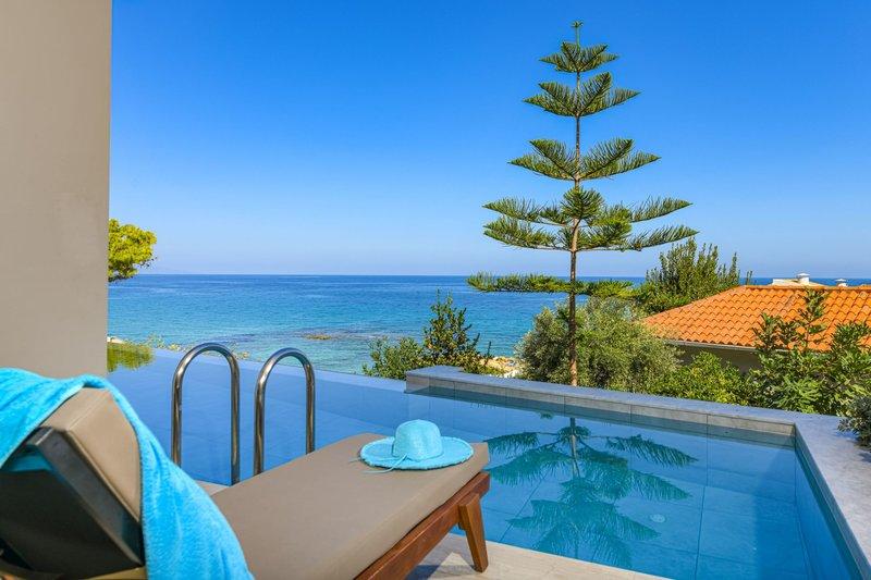 Außenansicht des Pools im Alexandra Beach Resort mit Blick auf das Meer und eine orangefarbene Dachterrasse.