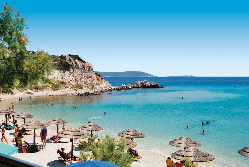 Strandansicht des Glicorisa Beach Hotel mit vielen Gästen, Sonnenschirmen und kristallklarem Wasser