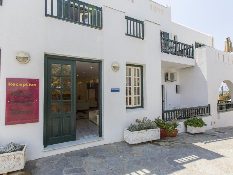 Vorderansicht des Golden Coast Hotels mit Rezeptionsschild, grünen Türen und Balkonen