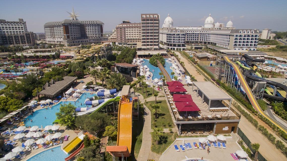 Luftaufnahme des Saturn Palace Resorts mit Wasserrutschen, Pools und Hotelgebäuden.