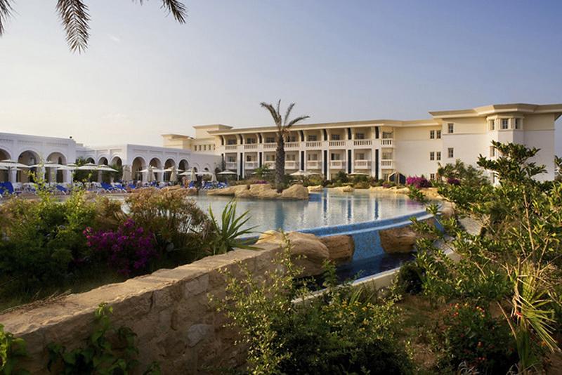 Außenbereich des Medina Belisaire & Thalasso Hotels mit Swimmingpool und Sonnenliegen.