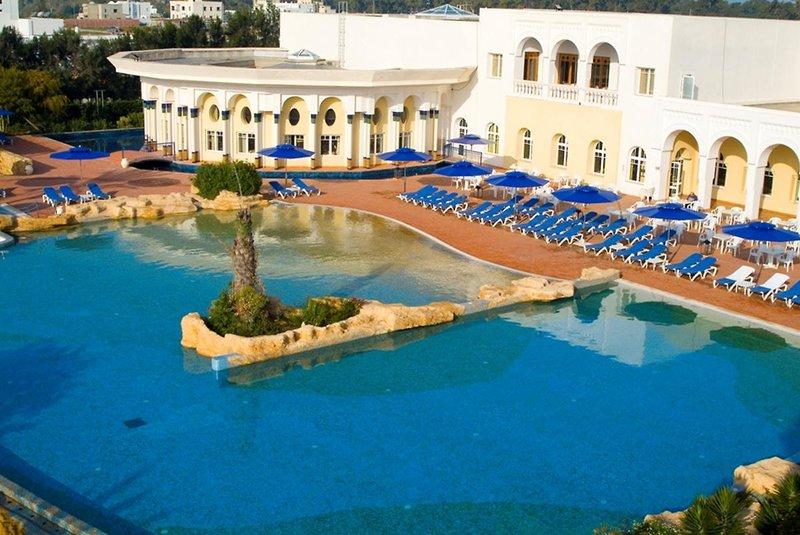 Außenpool des Medina Belisaire & Thalasso Hotels mit blauen Sonnenliegen und Schirmen